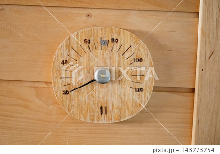 Wooden sauna thermometer on wall showing temperature in rustic interior Wooden sauna thermometer on wall showing temperature in rustic interior 143773754