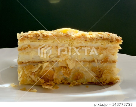 Piece of Napoleon cake on a plate. Slice of Mille-Feuille pastry on a plate. Piece of Napoleon cake on a plate. Slice of Mille-Feuille pastry on a plate. 143773755
