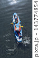 Aerial view of man paddling blue paddleboard Aerial view of man paddling blue paddleboard 143774854