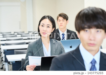 オフィスで資料を見ながらチームで仕事をする若い会社員 オフィスで資料を見ながらチームで仕事をする若い会社員 143775203