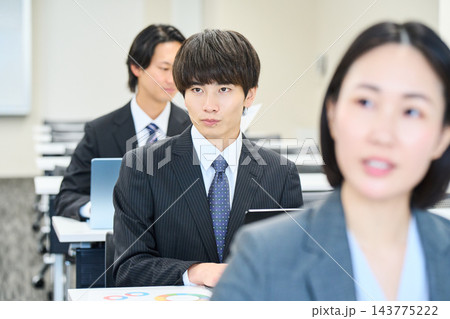 オフィスで資料を見ながらチームで仕事をする若い会社員 オフィスで資料を見ながらチームで仕事をする若い会社員 143775222