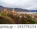 Ananuri Fortress complex with towers, churches and blossoming trees above reservoir in spring, Georgia 143776154
