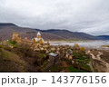 Ananuri Fortress complex with towers, churches and blossoming trees above reservoir in spring, Georgia 143776156