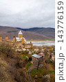 Ananuri Fortress complex with towers, churches and blossoming trees above reservoir in spring, Georgia 143776159