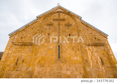 Carved stone cross on golden church gable at Ananuri Fortress, low angle, Georgia 143776162