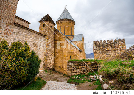 Ananuri church with conical roof, watchtower and cobblestone path in fortress, Georgia Ananuri church with conical roof, watchtower and cobblestone path in fortress, Georgia 143776166