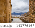 Stone passage between church wall and tower at Ananuri Fortress overlooking reservoir, Georgia 143776167