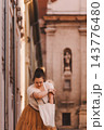 Woman Searching Tote Bag on Historic City Street 143776480