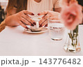 Woman Holding Coffee Cup at Outdoor Cafe 143776482