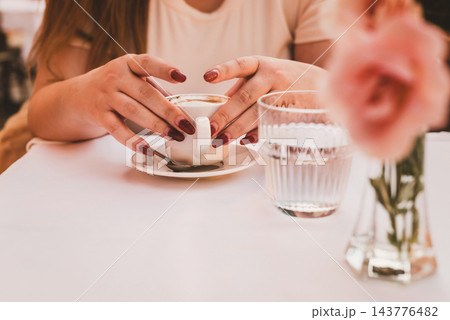 Woman Holding Coffee Cup at Outdoor Cafe Woman Holding Coffee Cup at Outdoor Cafe 143776482