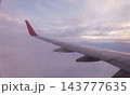 Beautiful salmon dawn and the wing of an airplane above the clouds. 143777635