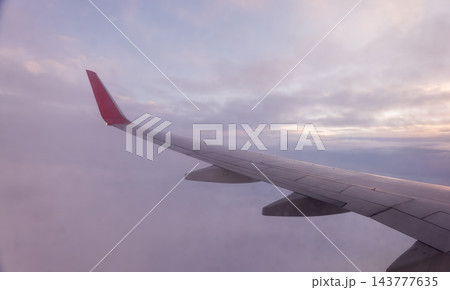Beautiful salmon dawn and the wing of an airplane above the clouds. Beautiful salmon dawn and the wing of an airplane above the clouds. 143777635