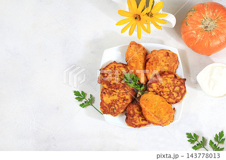 Delicious vegan Russian style pancakes ,blini with pumpkin, pumpkin seeds and parsley, served with a portion of sour cream on a kitchen table, concept for healthy, diet friendly eating. Delicious vegan Russian style pancakes ,blini with pumpkin, pumpkin seeds and parsley, served with a portion of sour cream on a kitchen table, concept for healthy, diet friendly eating. 143778013