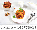 Delicious vegan Russian style pancakes ,blini with pumpkin, pumpkin seeds and parsley, served with a portion of sour cream on a kitchen table, concept for healthy, diet friendly eating. 143778015