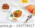 Natural vegan food.Delicious vegan Russian style pancakes ,blini with pumpkin, pumpkin seeds and parsley, served with a portion of sour cream on a kitchen table, concept for healthy, 143778017