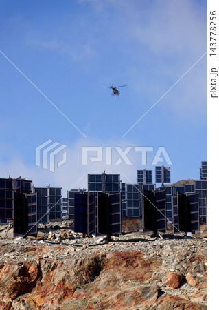 Helicopters flies on construction site of vertically mounted photovoltaic plant, solar panels, future innovation energy concept 143778256