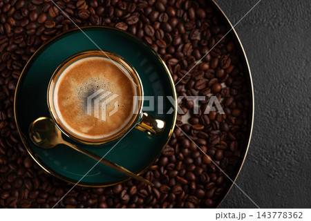 Fresh espresso in a green cup surrounded by coffee beans Fresh espresso in a green cup surrounded by coffee beans 143778362