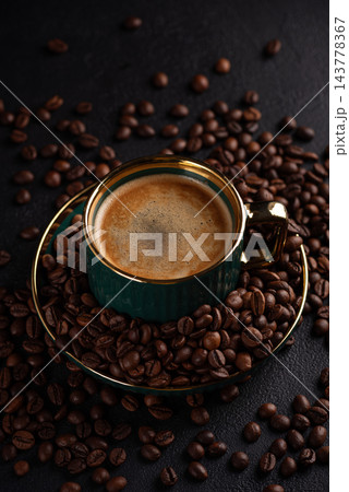 Fresh espresso cup surrounded by roasted coffee beans 143778367