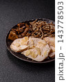 A bowl featuring slices of boiled chicken fillet, buckwheat noodles, and mushrooms 143778503