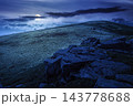 Carpathian mountain summer landscape at night. full moon over meadow with huge stones among the grass on top of the hillside near the peak of mountain range. dark sky. mysterious fantasy Carpathian mountain summer landscape at night. full moon over meadow with huge stones among the grass on top of the hillside near the peak of mountain range. dark sky. mysterious fantasy 143778688