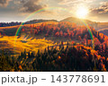 sunset over hillside of mountain range with mixed forest and alpine meadow in autumn colors. Apuseni national park under cloudy sky with rainbow. Romania in fall season sunset over hillside of mountain range with mixed forest and alpine meadow in autumn colors. Apuseni national park under cloudy sky with rainbow. Romania in fall season 143778691