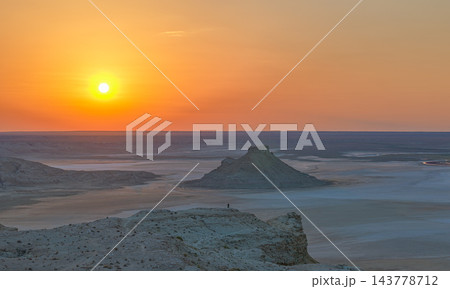 広いカリンジャリクの塩の盆地に沈むオレンジ色の夕日 143778712