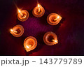 Diwali diyas glowing around a traditional rangoli 143779789