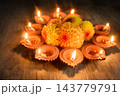 Diwali diya lamps glowing around marigold flowers 143779791