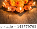 Diya oil lamps and marigold flowers celebrating diwali on a wooden surface 143779793