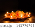 Diwali diyas burning around orange flowers in a festive arrangement 143779795