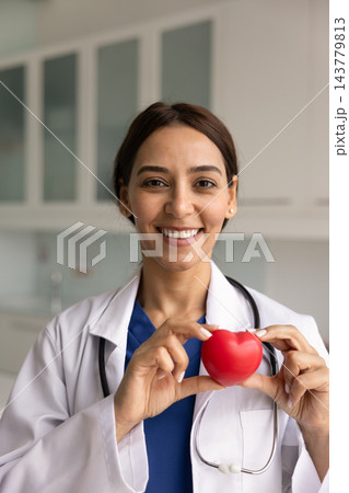 Portrait of female doctor holding red heart in hands Portrait of female doctor holding red heart in hands 143779813