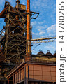 Vertical photo of historic blast furnace steel framework with bright orange conical exhaust stack connecting bridge truss and multi level stairs in Duisburg Ruhr region Westphalia Germany 143780265