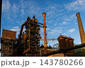 High angle telephoto landscape of historic blast furnace complex with orange conical exhaust stack cowper stoves brick smokestack and blue sky in Duisburg Ruhr region North Rhine Westphalia Germany 143780266
