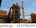 Vertical photo of historic blast furnace steel framework with bright orange conical exhaust stack multi tier catwalk stairs and rusty gas pipelines in Duisburg Ruhr region Westphalia Germany 143780269