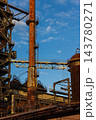 Vertical photo of historic blast furnace bright orange conical exhaust stack vertical ladders connecting bridge truss cowper stove and blue sky in Duisburg Ruhr region Westphalia Germany 143780271