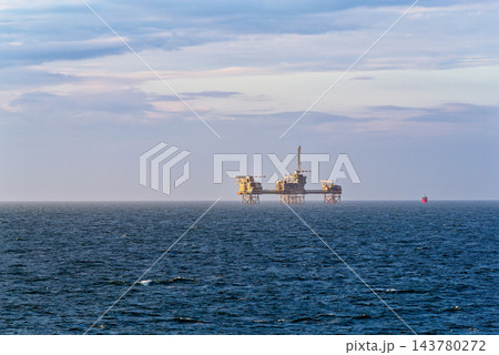 Offshore platform on calm sea under pastel sky 143780272