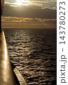 Golden sunset over shimmering sea from ship rail 143780273