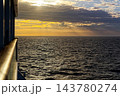 Golden sunset over shimmering open sea from ship rail 143780274
