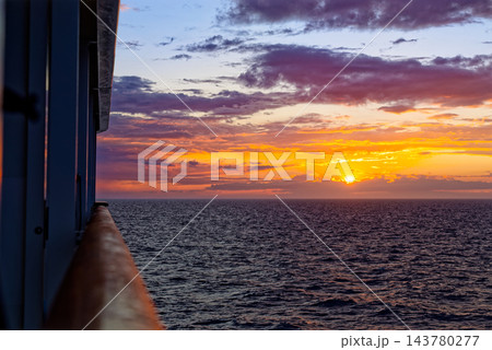 Sunset over open sea viewed from ship rail 143780277