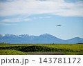 旭川空港周辺から撮影した十勝岳連峰と着陸する飛行機 143781172