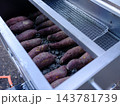 黒い小石の上に並ぶ石焼き芋　秋冬の味覚と日本の伝統的な食文化 143781739