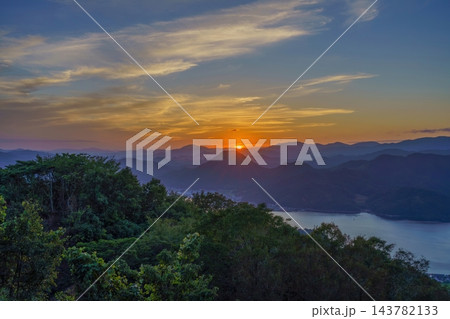 新しい始まりや希望を象徴する山並みに沈む夕日と澄み渡る美しい自然風景 新しい始まりや希望を象徴する山並みに沈む夕日と澄み渡る美しい自然風景 143782133