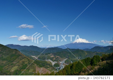 【静岡県】山あいの向こうにそびえる雪の富士山 山原から望む冬晴れ 【静岡県】山あいの向こうにそびえる雪の富士山 山原から望む冬晴れ 143782171