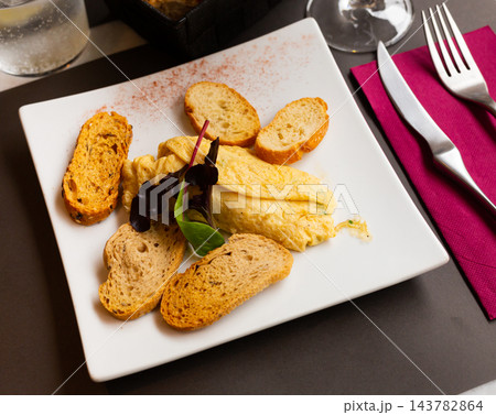 Stuffed french omelet with toasted baguette and greens Stuffed french omelet with toasted baguette and greens 143782864