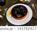 Closeup of deliciously appetizing steamed mussel with lemon on clay plate 143782917