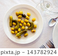 Green olives served with cucumber and onion on plate 143782924