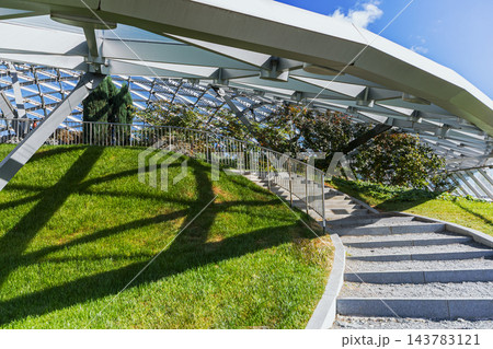 Modern Glass Canopy Over Green Landscaped Park Modern Glass Canopy Over Green Landscaped Park 143783121