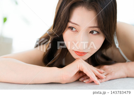テーブルに腕を置いて物思いにふける美しい女性。美容・ビューティー 143783479