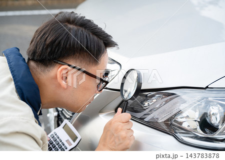 車の傷を確認する男性 143783878