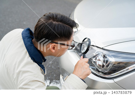 車の傷を確認する男性 143783879
